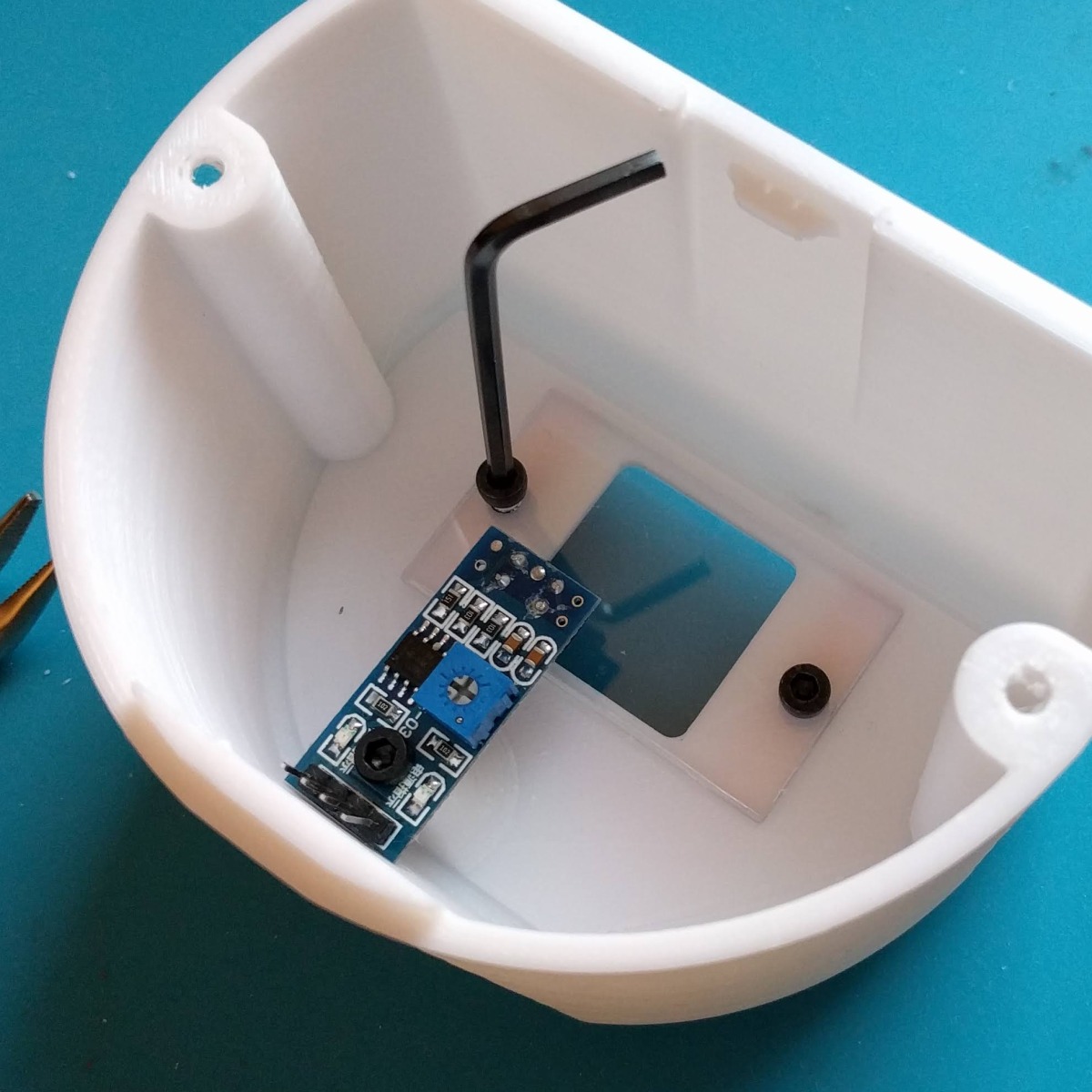 The pins on the sensor board have to be bent up before fastening it inside the cover