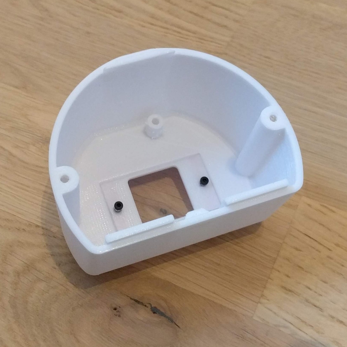 The two screws hold both the window and the curb in place