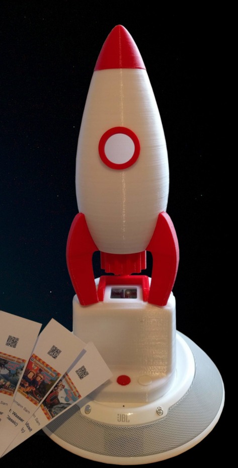 The Qudio player (with the additional rocket). The QR cards are placed on the window on top of the case, where they are detected by a photo sensor that triggers the recognition process. After the code has been read by the webcam, the music starts playing.